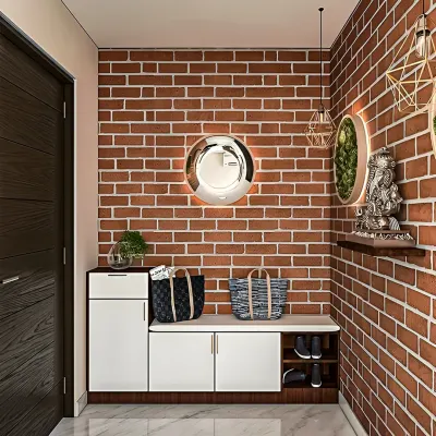 An industrial-chic entryway featuring a white storage bench with shoe compartments against a rustic red brick wall. A statement mirror and modern lighting complete the look.