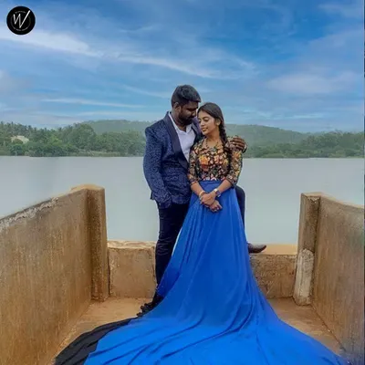 This scenic lakeside shot highlights one of our popular pre-wedding rental packages. The royal blue trail gown and coordinated blue patterned blazer create a cohesive and visually striking look for any couple's photoshoot.