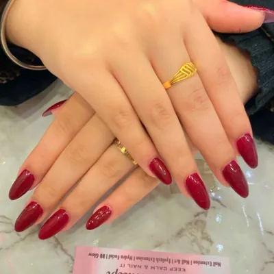 A classic and powerful look with long, stiletto-shaped nails in a glossy, deep red polish. This timeless choice is always in style.