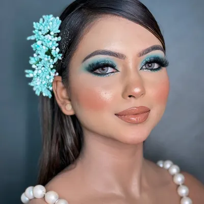 A full-face view of the blue smokey glittery eye makeup. This look is perfect for a cocktail party or reception, pairing the dramatic eye with a glossy nude lip and contoured cheeks to create a balanced, high-fashion look.