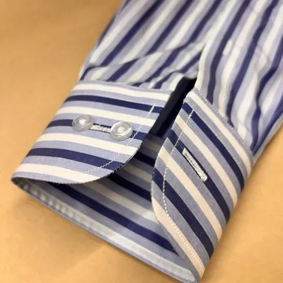 The cuff of a bespoke shirt is a mark of quality. This example, made from Thomas Mason fabric, features a classic two-button design and precise stitching for a sharp finish.
