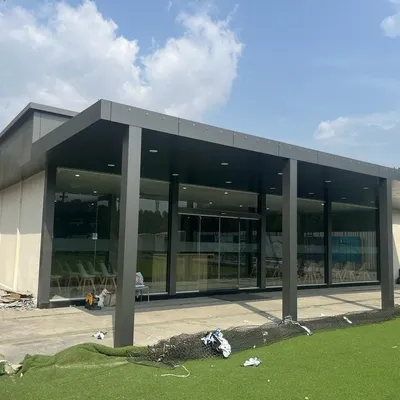 This is a large prefab administrative office building I constructed. It features a modern design with a covered entryway and extensive glass walls, providing a professional and comfortable workspace that can be assembled much faster than a traditional building.