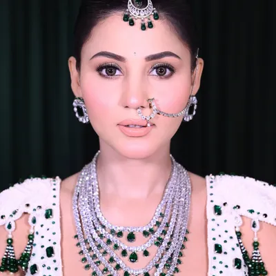 A close-up of a classic bridal look, focusing on the soft glam eye makeup and perfectly defined nude lips. The right jewelry placement, like the maang tikka and nath, enhances the entire face.