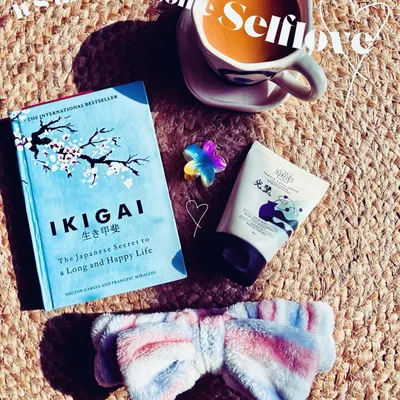 A self-care moment featuring the book 'Ikigai' and a K-beauty face mask. I create aesthetic flatlays that position products within a context of wellness, reading, and relaxation.