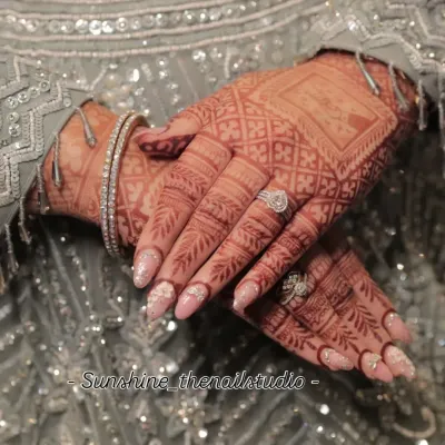 A beautiful shot of my bridal nail art, designed to perfectly complement the intricate henna. This set features a soft pink base with 3D flowers and a delicate sugar glitter effect.
