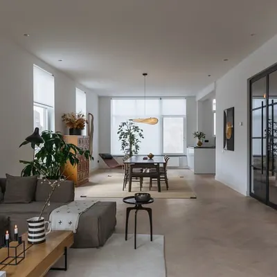 The open-plan living and dining area of the Corner House in Rotterdam. We designed the space to be fluid and connected, using a neutral palette and consistent oak flooring to create a sense of spaciousness and light.