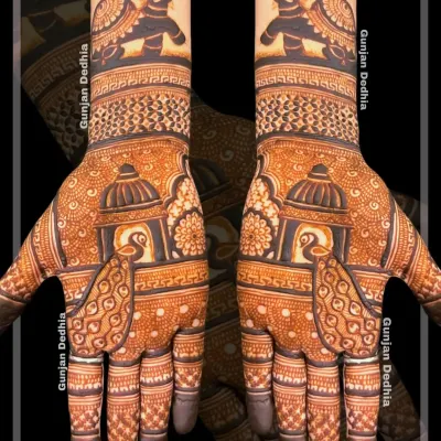 A stunning example of symmetrical traditional mehendi. Both hands feature a mirror design of peacocks in a jharokha and elephants on the wrists, creating a balanced and regal look.
