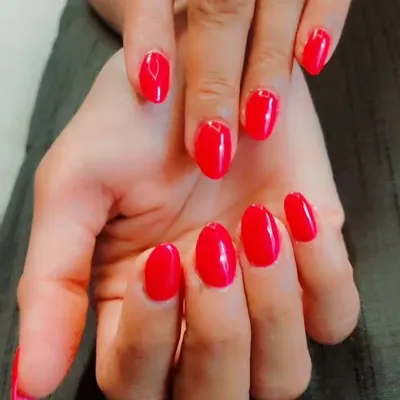 A classic and confident choice. This is a simple manicure with a vibrant, glossy red gel polish on perfectly shaped oval nails.