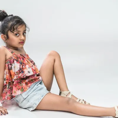 A modern and stylish portrait of a young model. The pose is confident and the simple studio background keeps the focus on her, making this a great addition to a child actor's or model's portfolio.