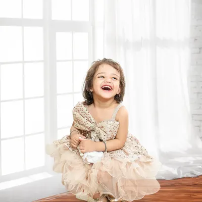 A moment of pure, unscripted laughter. This classic portrait against a bright, clean background focuses entirely on her joyful expression.