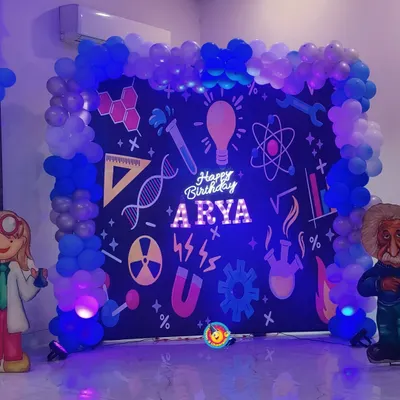 For Arya's birthday, I designed a fun and educational science theme. The backdrop was styled like a chalkboard filled with scientific symbols, framed by a blue balloon arch and featuring cutouts of famous scientists.