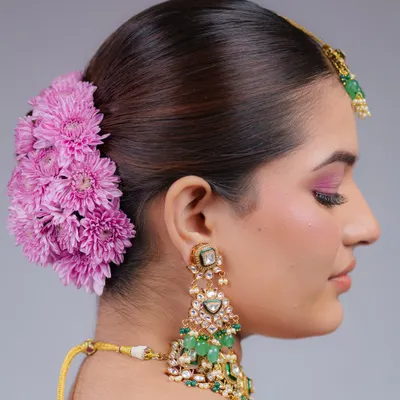 A side profile of this gorgeous floral bun, showing how the fresh flowers are carefully placed to complement the bride's jewelry and makeup.