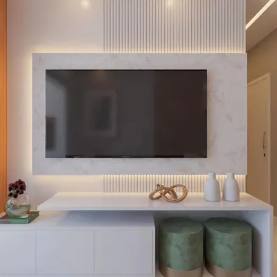 A close-up of a modern, minimalist TV unit. This design features a floating console with both closed cabinets and open shelving, set against a backdrop of white marble and fluted panels with subtle backlighting.