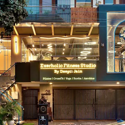 A full view of our studio facade at dusk. We wanted to create a space that looks as good on the outside as it feels on the inside. You can see our offerings listed right on the front: Pilates, CrossFit, Yoga, Zumba, and Aerobics.