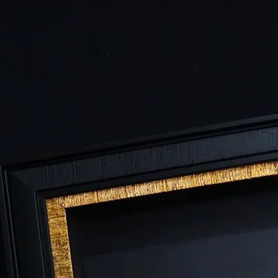 A close-up of a premium black frame with a textured gold inner border. I will teach you how to source and assemble frames like this to give your final product a professional and luxurious feel.