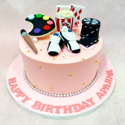 This "Favourite Things" cake is a celebration of hobbies, topped with an artist's palette, popcorn, playing cards, sneakers, and a movie reel.