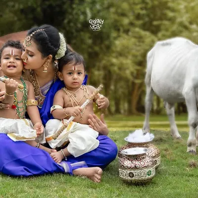 A mother's love is the purest of all. Here, a loving mother embraces her two little Krishnas in a beautiful outdoor setting, creating a memory of unending love.