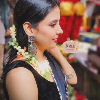 A beautiful side profile from a "market theme" photoshoot. The makeup is natural and sunkissed, with fresh flowers in the hair to complement the vibrant setting.