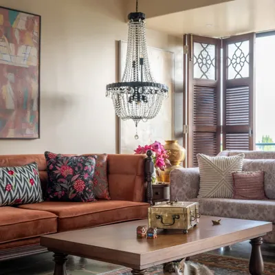 This living room in Calcutta is designed to hold everyone, including Peru the cat, seen here under the coffee table. The warm, earthy tones and comfortable upholstery invite you to sink in and stay awhile, creating a space that feels like a true family hub.
