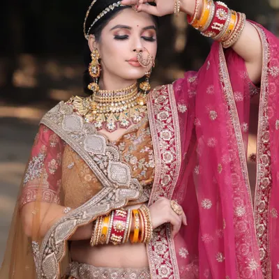 A beautiful and romantic bridal portrait. This look features a soft, glowing base with warm, earthy tones on the eyes, perfectly complementing the mustard and pink lehenga.