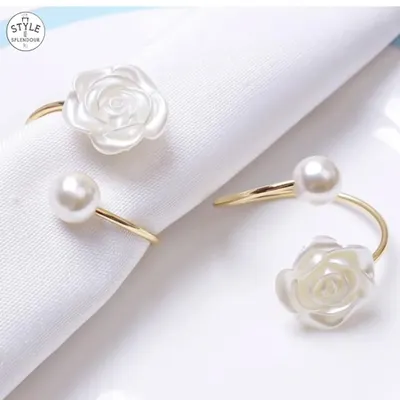 A close-up of my pearl and white rose napkin rings. The combination of the lustrous pearl and the delicate flower on a gold-finish ring adds a touch of romance and sophistication to a simple white napkin.