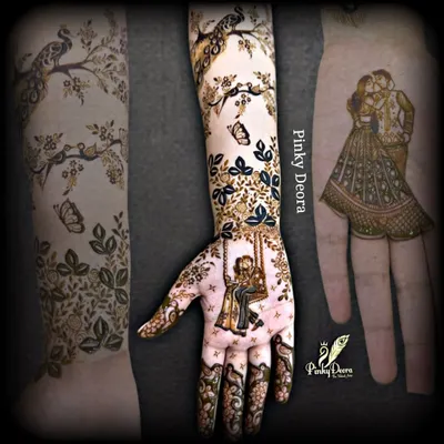 A narrative design showing a couple on a swing on the palm, with the story continuing up the arm with birds and butterflies. This is the art of storytelling in mehndi.