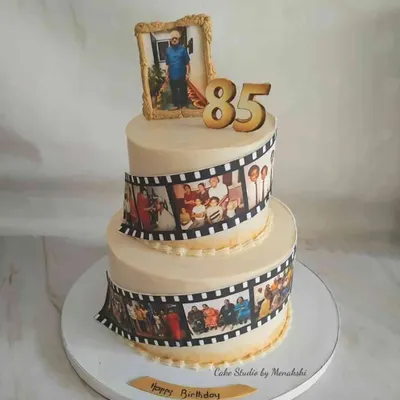 A grand two-tier cake to celebrate an 85th birthday. I used edible photo strips to create a film reel of cherished family memories, wrapping them around the cake for a truly personal touch.