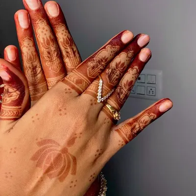 The final stain is the true test of quality. This photo shows the rich, reddish brown color of a fully developed henna design, featuring a delicate lotus and detailed finger patterns.