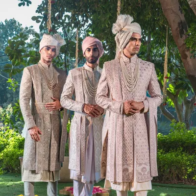 A portrait of royal elegance, this trio of groomsmen and groom showcases our ability to create a cohesive wedding party aesthetic. Each sherwani, complete with a traditional safa, is a masterpiece of coordinated design and individual tailoring.