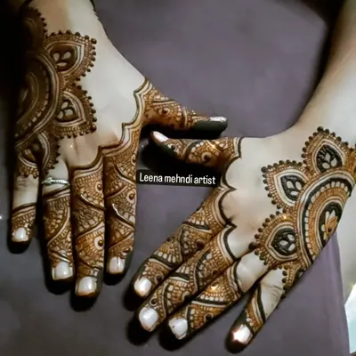 A beautiful example of a modern Arabic design. The pattern flows gracefully across the back of the hands, using negative space to create a delicate, jewelry-like effect.