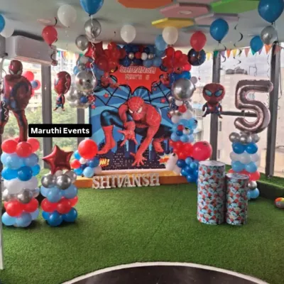 A full-scale Spiderman celebration for a 5th birthday. This setup includes a large city-scape backdrop, multiple Spiderman balloon figures, and themed columns, creating an immersive New York City for the little hero.