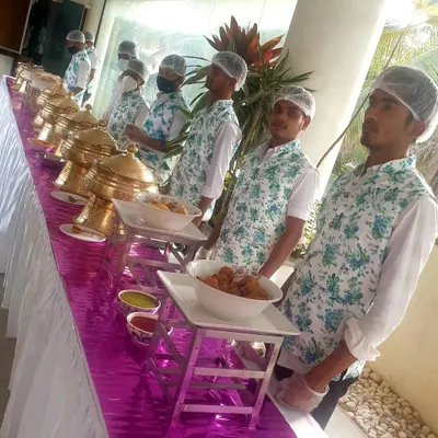 My service staff in their clean, floral-print uniforms, wearing hairnets and gloves as they stand ready at the buffet line. I prioritize hygiene and a professional appearance at every event.