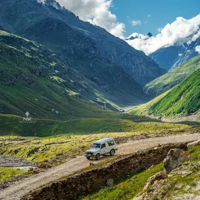 A wide, epic shot of an SUV navigating a mountain pass in Spiti. This type of image is perfect for brand campaigns focused on exploration and the call of the open road.