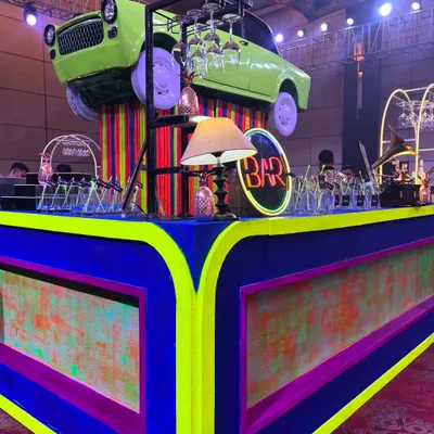 Our signature vintage car bar setup. This fully custom-built bar features a retro car, vibrant neon-colored panels, and classic props, making it an instant photo opportunity for guests.