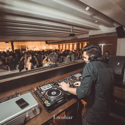 A wide view from behind the console at Escobar, showing a full house ready for a night of desi beats and commercial hits.