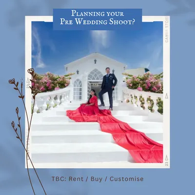 Make a grand statement with this fiery red trail gown against a stunning white architectural backdrop. This is one of our most popular rental looks for pre-wedding shoots, offering a powerful and cinematic visual. The groom's classic suit completes this elegant couple's portrait.