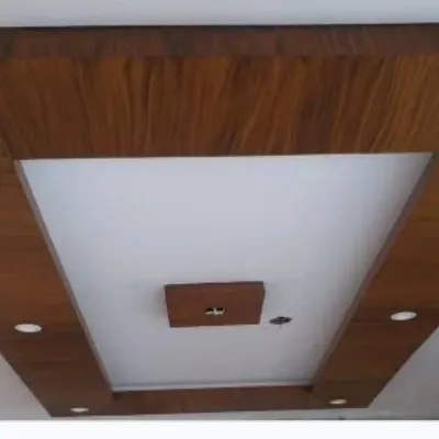 A finished false ceiling featuring a combination of white paint and a rich, wood-finish laminate. We execute these designs with precision for a polished and luxurious look.