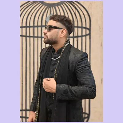 This is a perfect example of modern fusion wear. A client is wearing a black Indo-Western jacket with a matching draped kurta and a stylish scarf.
