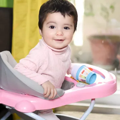 A happy smile from her baby walker. At-home lifestyle sessions are all about capturing your child's daily life and genuine expressions in their own environment.