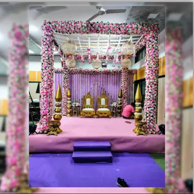 A fairytale mandap for a memorable ceremony. This square mandap is heavily decorated with pink and white flowers, featuring elegant birdcage chandeliers that add a touch of whimsy and romance to the wedding rituals.