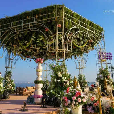 A mandap that feels like a floating garden against the sky. I designed this magnificent structure with a dense canopy of flowers, creating a heavenly space for the couple to exchange their vows by the sea.