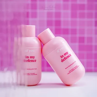 A creative shot of a pink moisturizer bottle, using motion blur effects in the foreground to draw the eye. This technique adds a dynamic and artistic feel to a standard product photo.