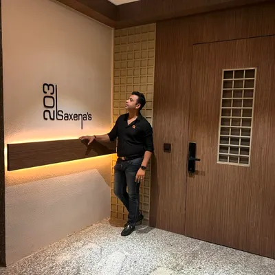 The main entrance transformation is complete. I designed this foyer with a custom backlit nameplate, wood-paneled walls, and a new door to create a warm and welcoming first impression.