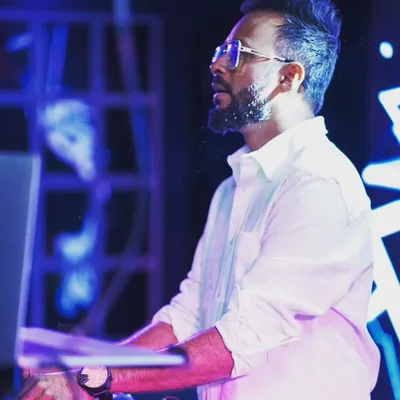 A candid shot of me focused on the mix during a "Friday Shuffle" event. Sometimes a simple white shirt is all you need to command the stage.