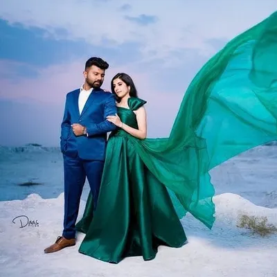 A dramatic emerald green gown with a long, flowing trail, perfect for a pre-wedding photoshoot. I designed this to create a striking contrast against any backdrop.