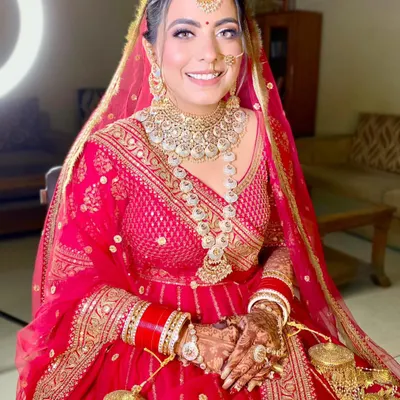 My gorgeous bride Neha is a vision in red. This look features a classic red lip, defined eyes, and radiant skin, perfectly complementing her traditional bridal attire.