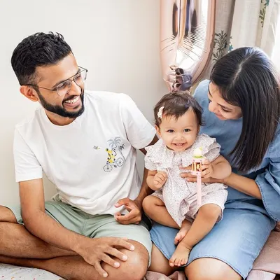 A happy family moment on the bed, celebrating their daughter's first birthday. These candid, at-home sessions are all about capturing genuine smiles and interactions.