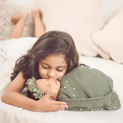 A tender kiss for a new baby sister. These are the moments we live for, capturing the beginning of a lifelong friendship in our newborn and sibling sessions.