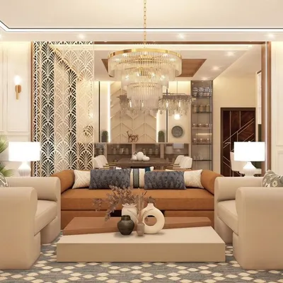 This luxurious living room features a double-height ceiling and a grand chandelier, creating an immediate sense of scale and opulence. The neutral color palette and elegant furnishings are complemented by a geometric jaali screen, adding a touch of traditional Indian craftsmanship to the modern design.
