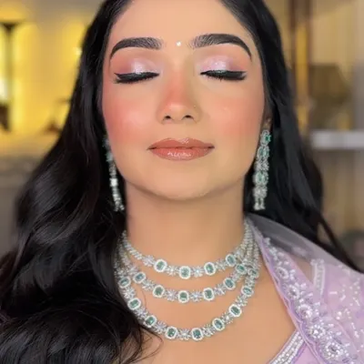 A close-up of this bride-to-be's soft glam look. The focus is on the shimmery pink eyeshadow and perfectly blended, glowing skin, ideal for an engagement ceremony.